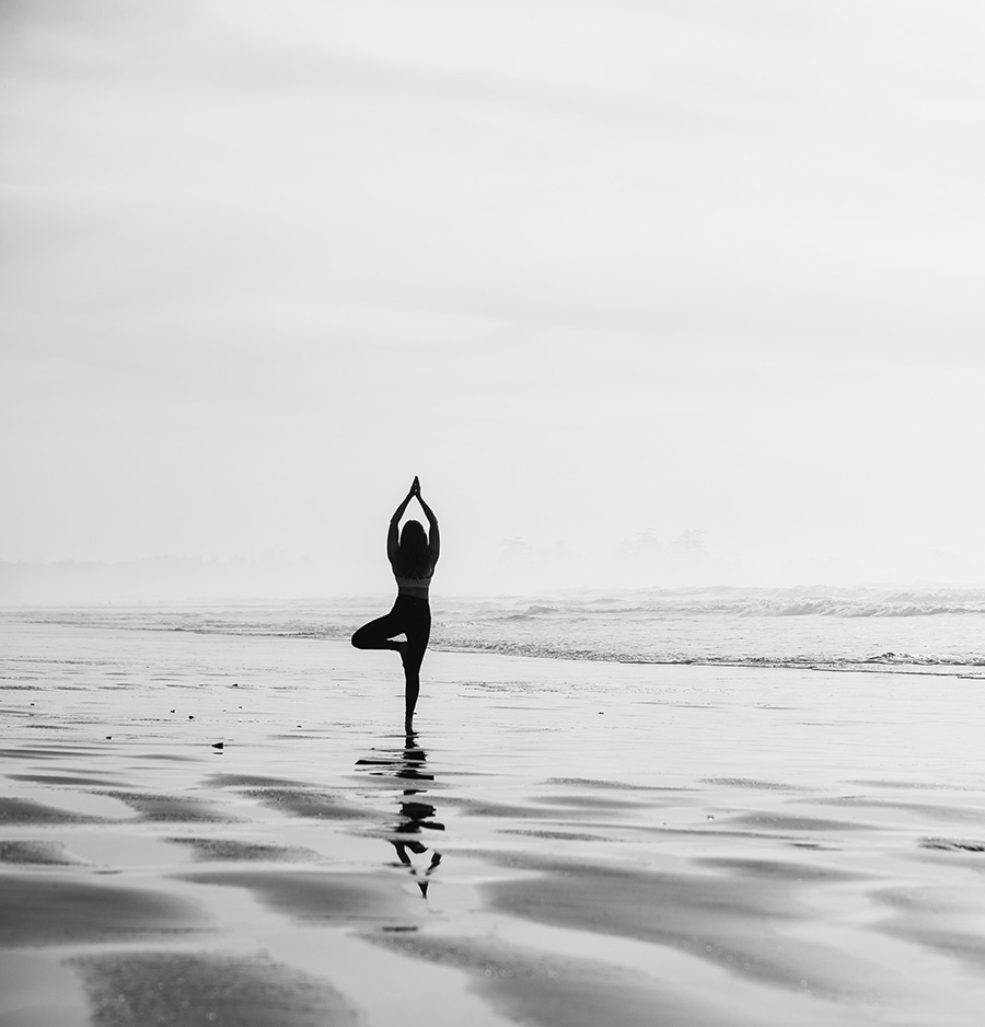 Laura meditating and stretching at the beach