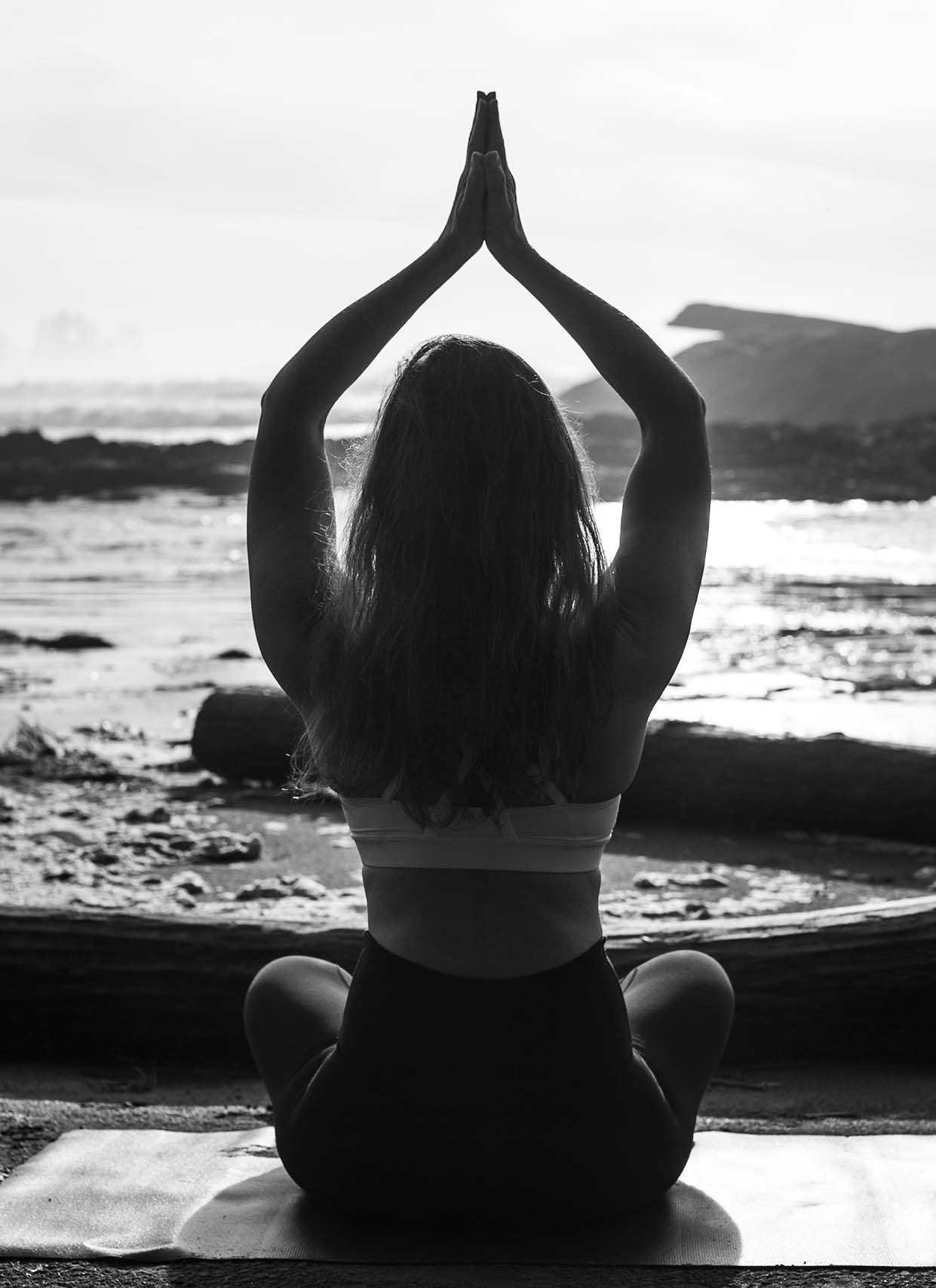 Laura, founder of Tofino Breath and Meditation, meditating by the beach
